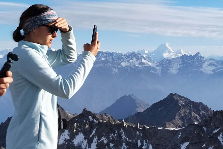 Traveler taking a photo of the mountain scenery with a smartphone.