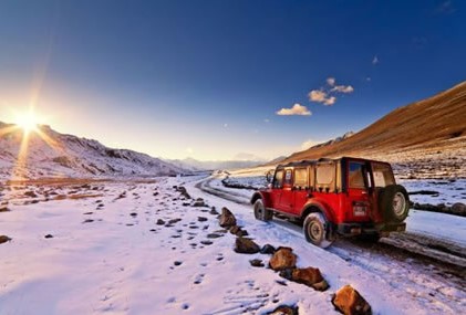 A scenic trekking route, featuring stunning mountain views and a vibrant red jeep under a colorful sky.