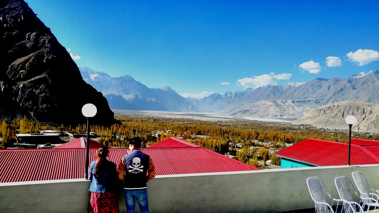 Paragliding Preparation – couple getting ready for paragliding on a hilltop
